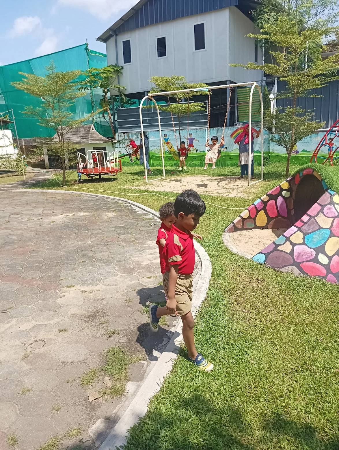 Child playing beside the grassy playground