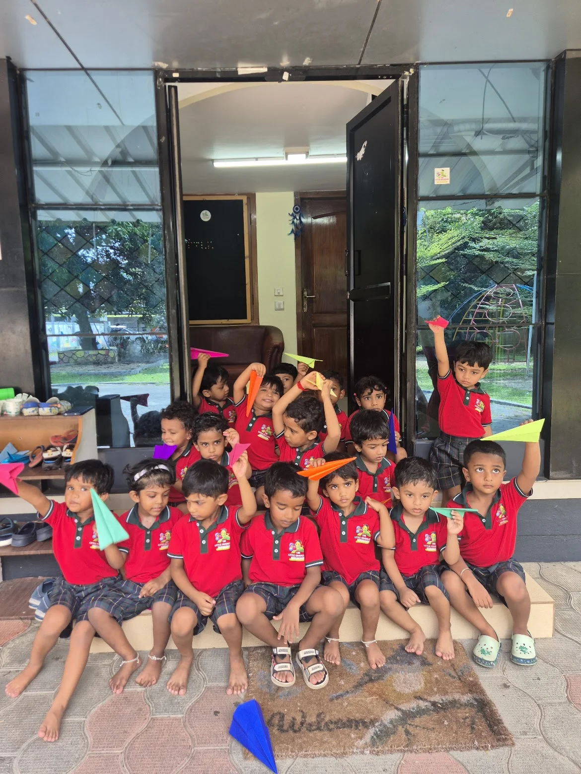 Children holding colourful paper planes together