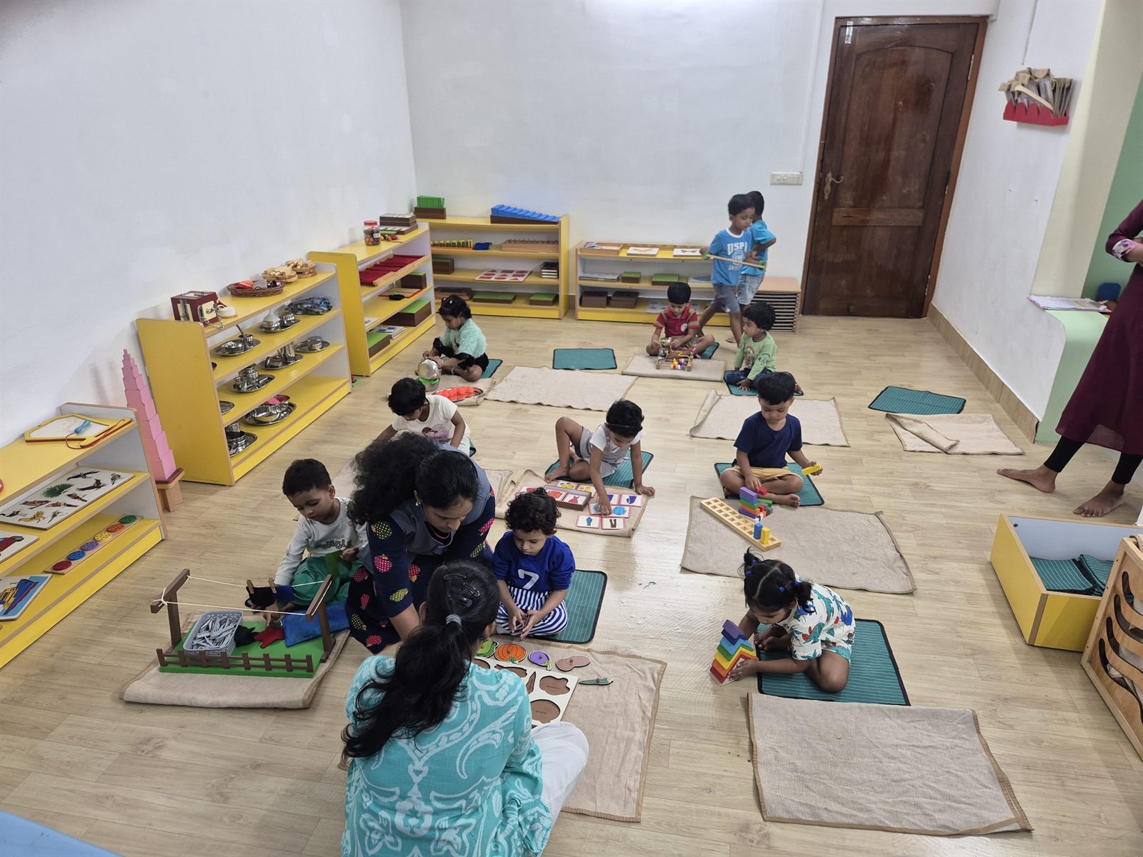 Children working on floor mats in the Montessori classroom