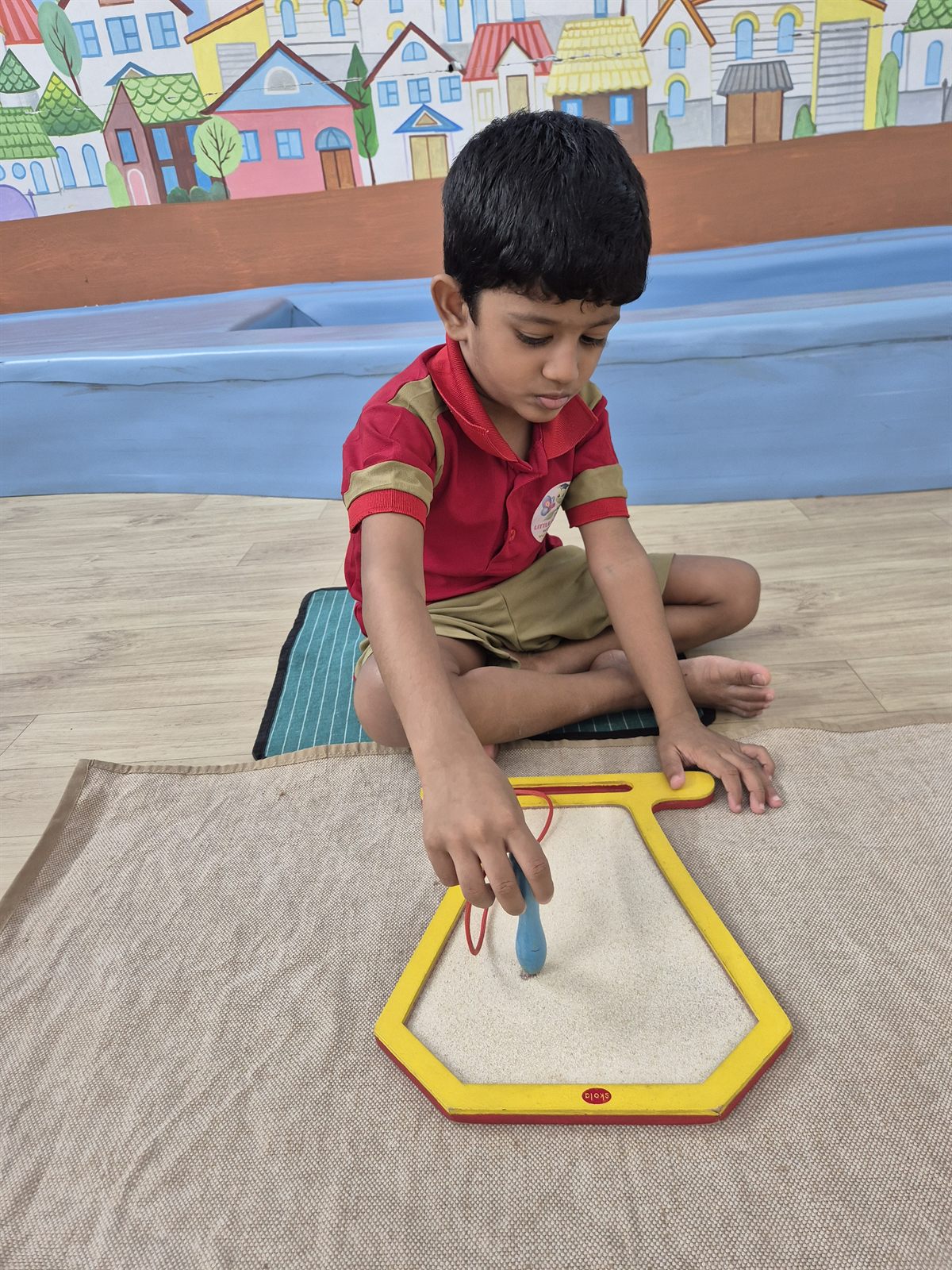 Child tracing a metal inset shape