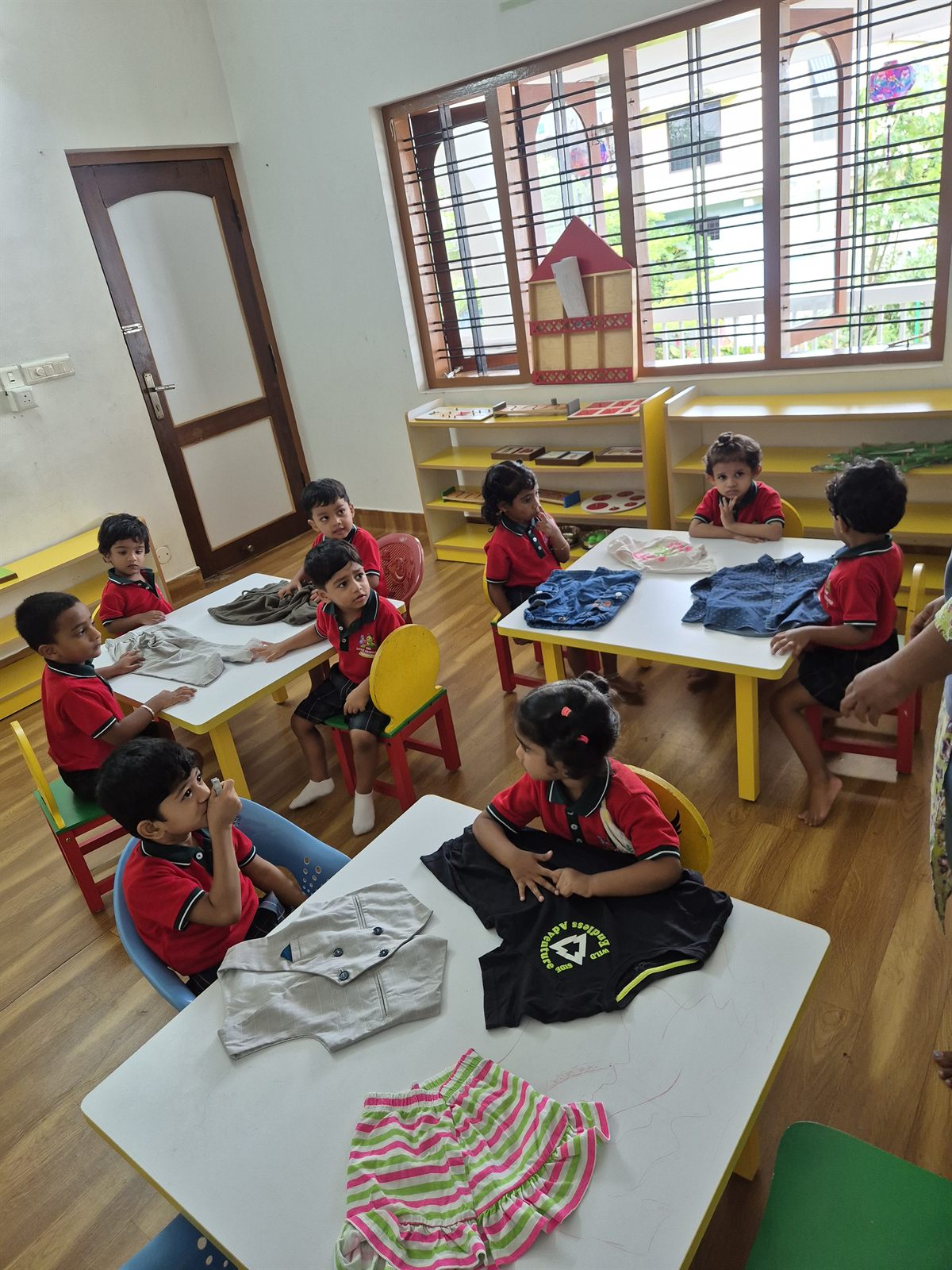 Children drawing at tables in a bright classroom
