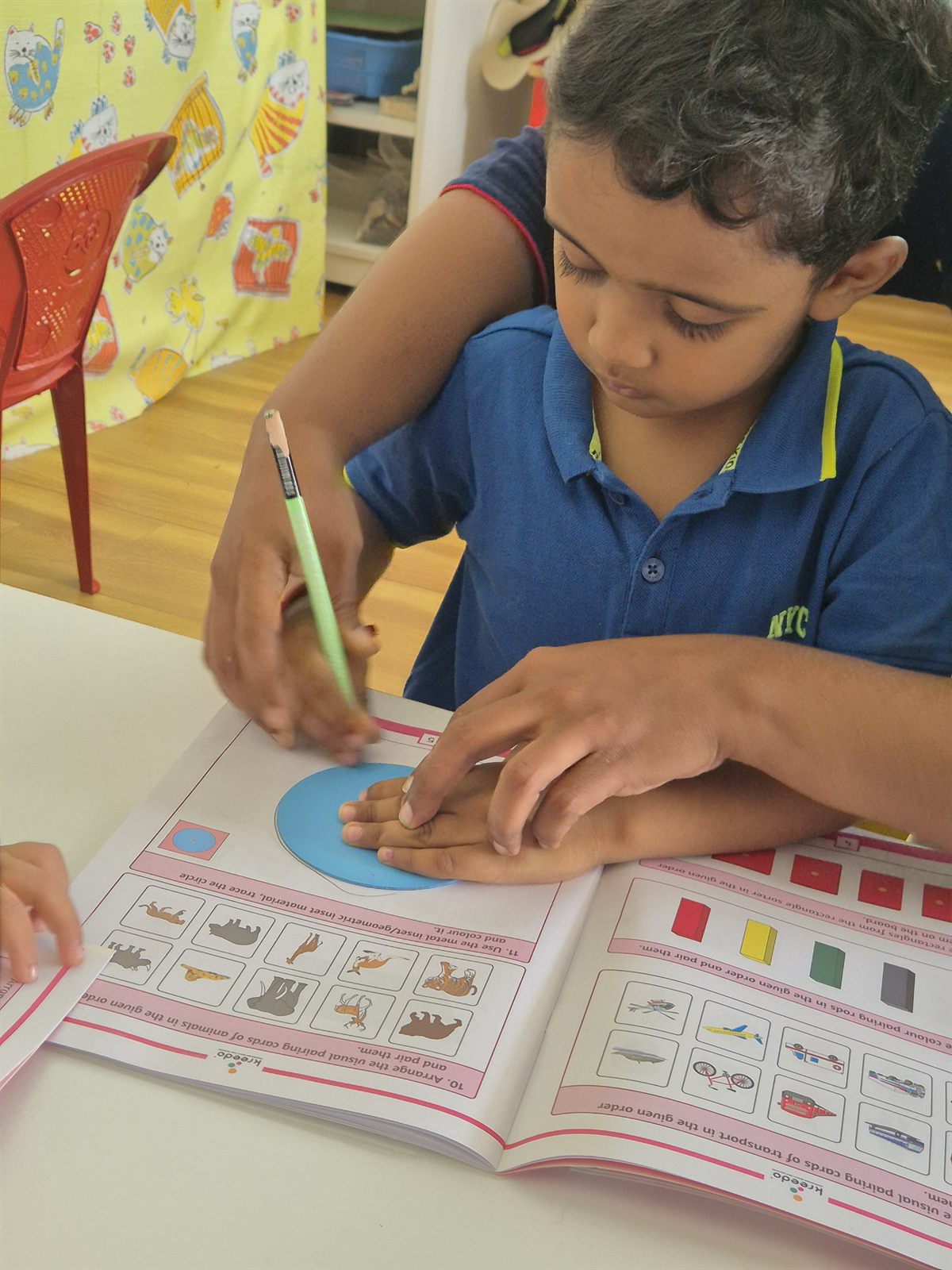 Child colouring in a workbook