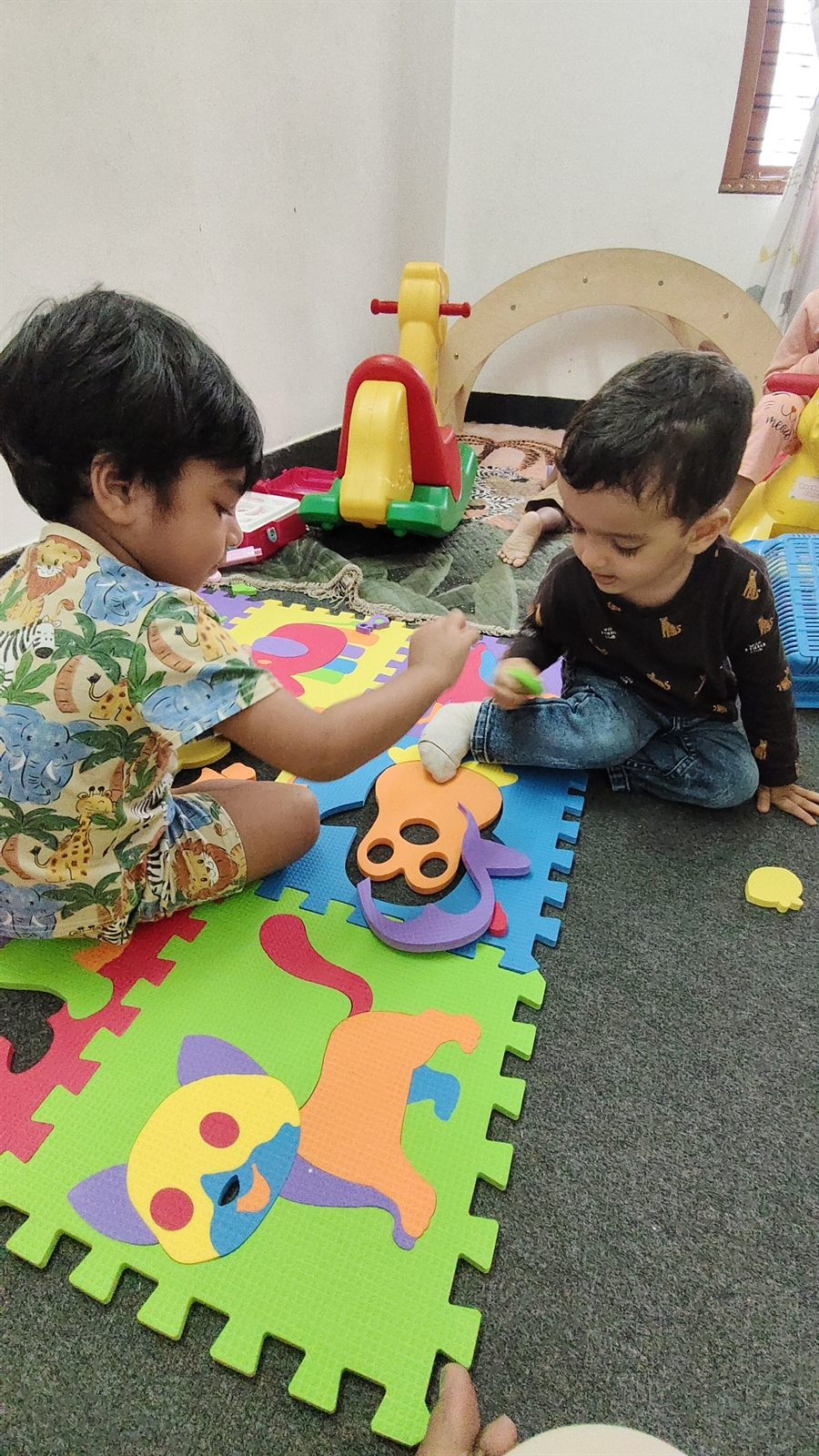 Toddlers playing on a soft foam play mat